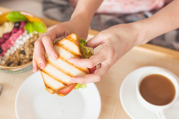 Foto gratuita primer plano de la mano de la mujer con sandwich