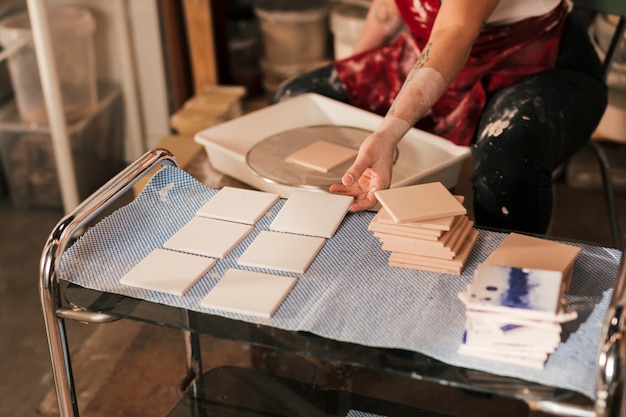 Primer plano de la mano de la mujer secando los azulejos blancos.