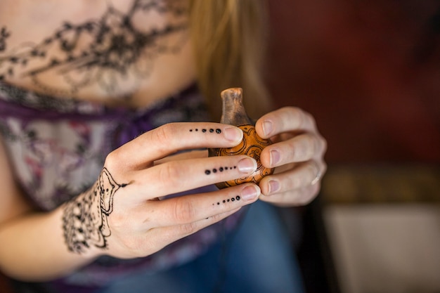 Primer plano de la mano de la mujer sosteniendo el antiguo recipiente de madera