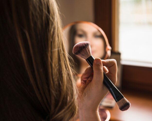 Primer plano de una mano de mujer sosteniendo colorete