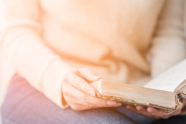 Primer plano de la mano de la mujer sosteniendo el libro en la mano