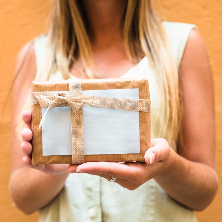 Foto gratuito primer plano de la mano de una mujer sosteniendo el regalo de san valentín