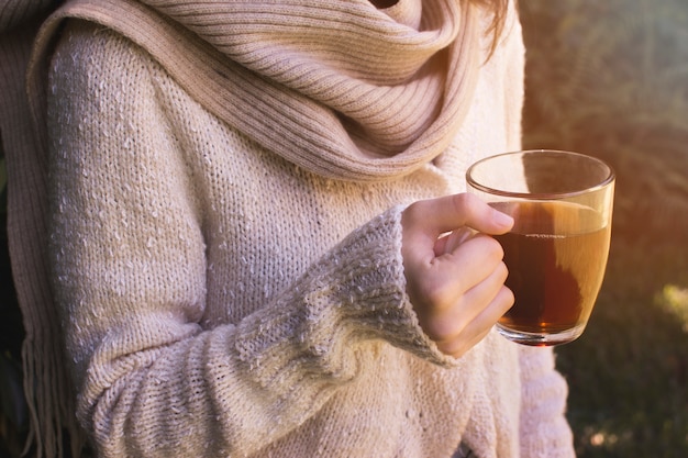 Primer plano de la mano de una mujer sosteniendo la taza de té