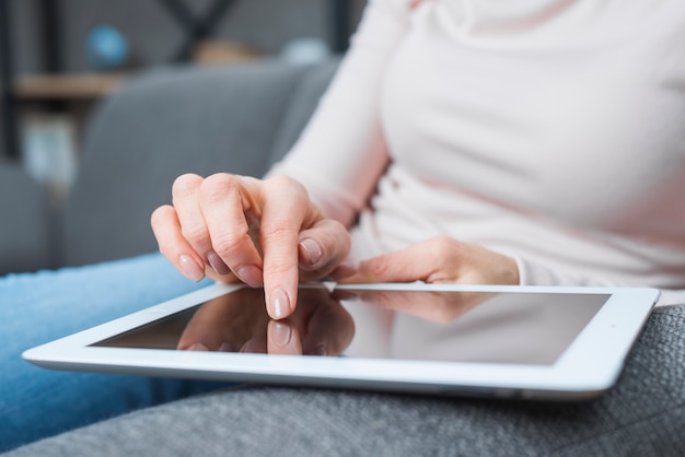 Foto gratuita primer plano de la mano de la mujer tocando la pantalla digital moderna con el dedo