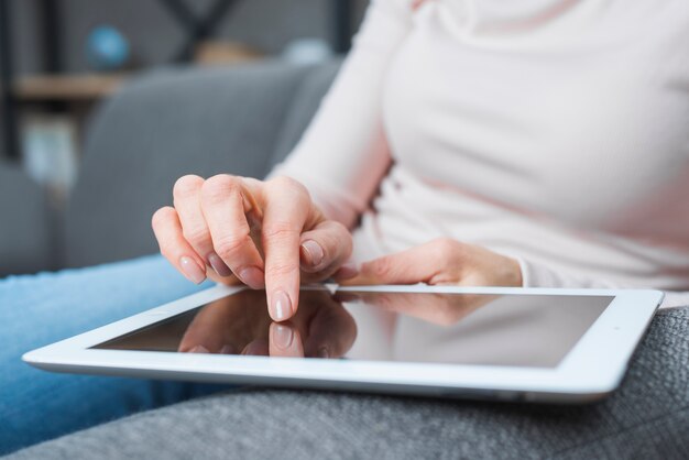 Primer plano de la mano de la mujer tocando la pantalla digital moderna con el dedo