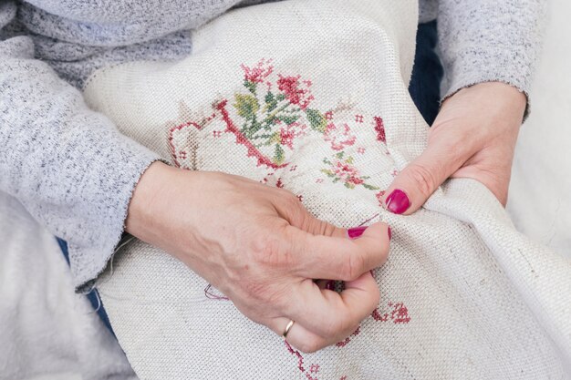 Primer plano de la mano de la mujer trabajando en un bordado