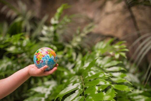 Primer plano de la mano del niño que sostiene la bola del globo inflable