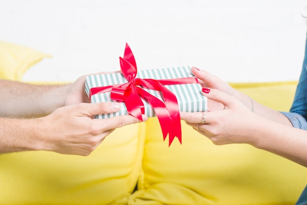 Primer plano de la mano de una pareja con regalo de San Valentín