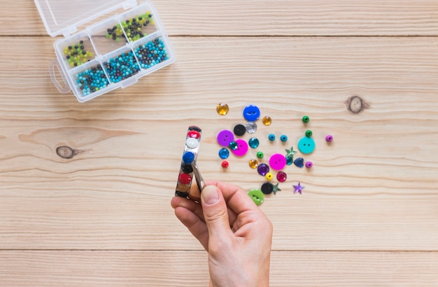 Foto gratuita primer plano de la mano de la persona pegando perlas de colores en la pulsera