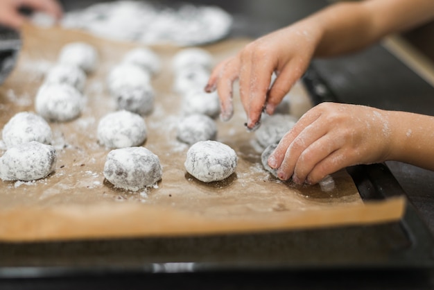 Primer plano de la mano de la persona preparando galletas