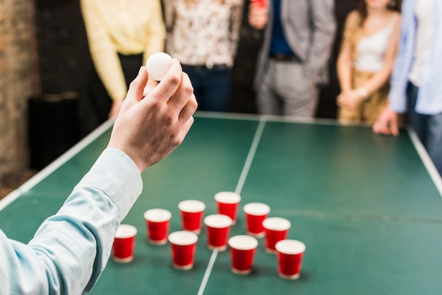 Foto gratuita primer plano de la mano de la persona que sostiene la bola para el juego de la cerveza pong