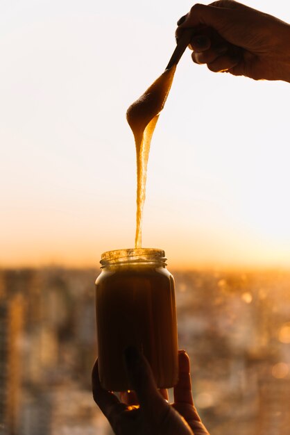 Primer plano de la mano de la persona con el tarro de crema de limón