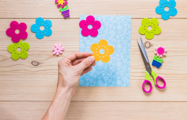 Primer plano de mano preparando la tarjeta de felicitación en la mesa de madera