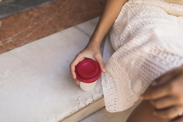 Primer plano de la mano que sostiene la taza de café disponible