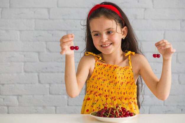 Primer plano de mano sosteniendo cerezas rojas frescas