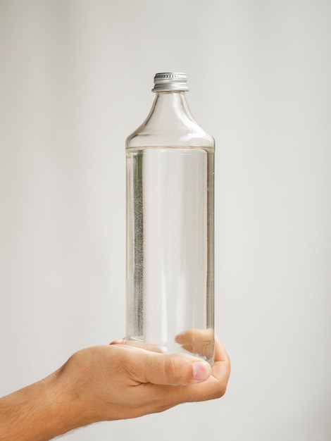 Primer plano mano sosteniendo maqueta de botella de agua