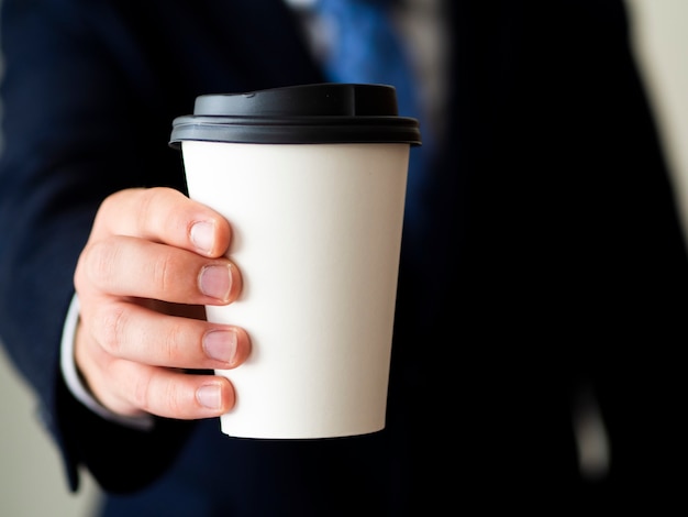 Primer plano mano sosteniendo maqueta de taza de café