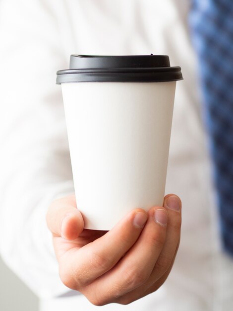 Primer plano mano sosteniendo maqueta de taza de café