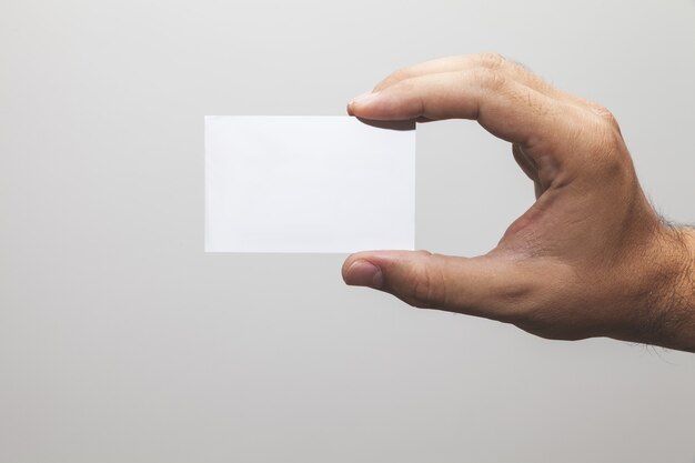 Primer plano de una mano sosteniendo un papel en blanco