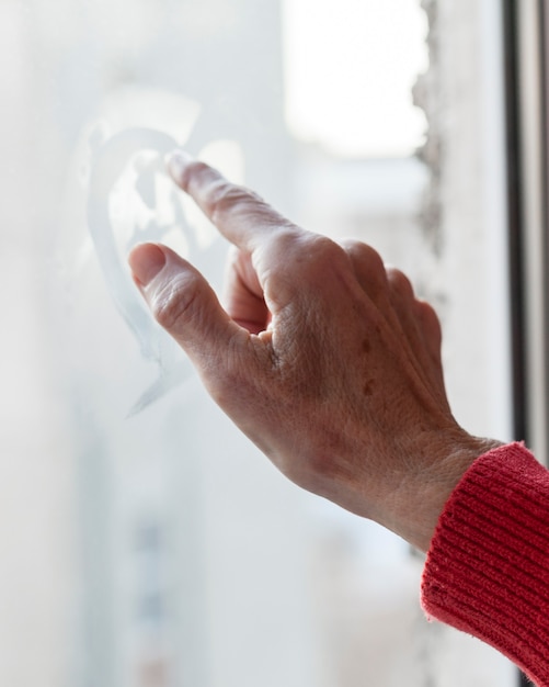 Primer plano de la mano tocando la ventana