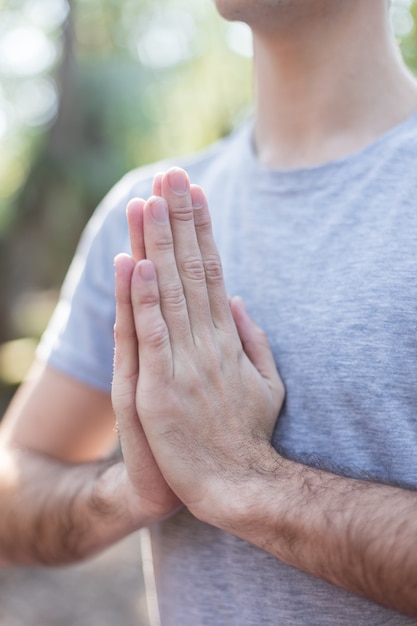 Primer plano de las manos de un adoslescente en pose de yoga