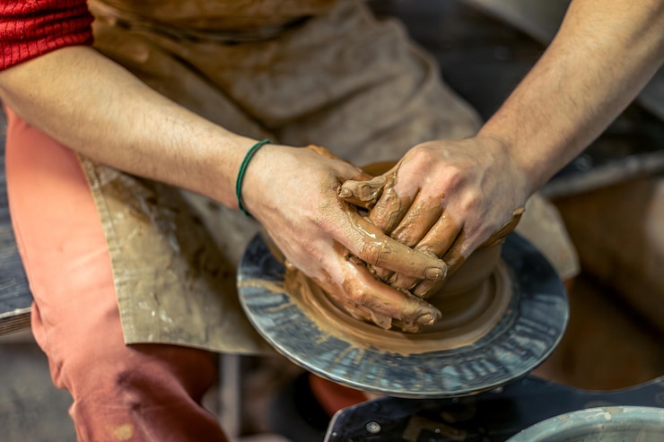 Foto gratuito primer plano de las manos de los alfareros masculinos haciendo un jarrón cerámica haciendo cerámica