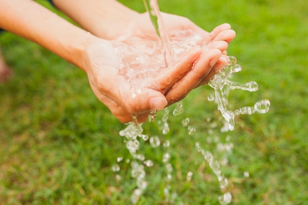 Primer plano de manos debajo de un chorro de agua