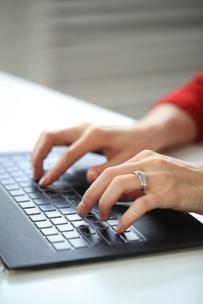 Primer plano de manos escribiendo con teclado de computadora