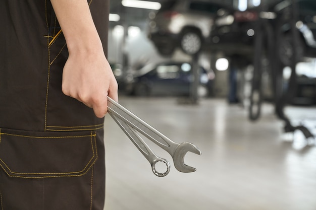 Primer plano de manos femeninas manteniendo llaves en taller