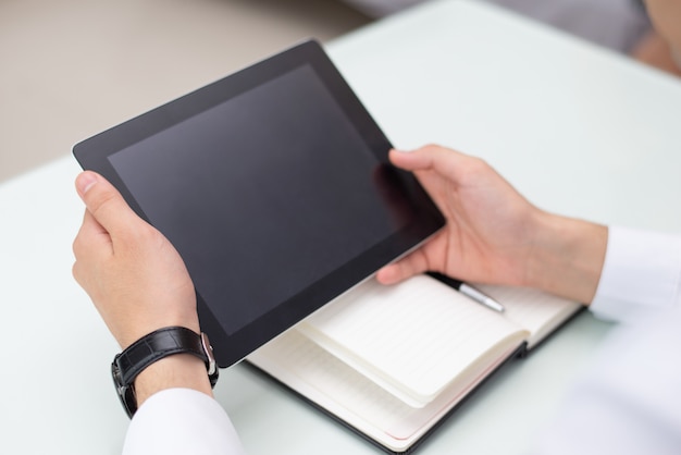 Primer plano de manos masculinas con tableta digital en la oficina