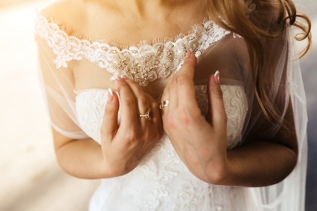 Primer plano de manos de la novia con anillos
