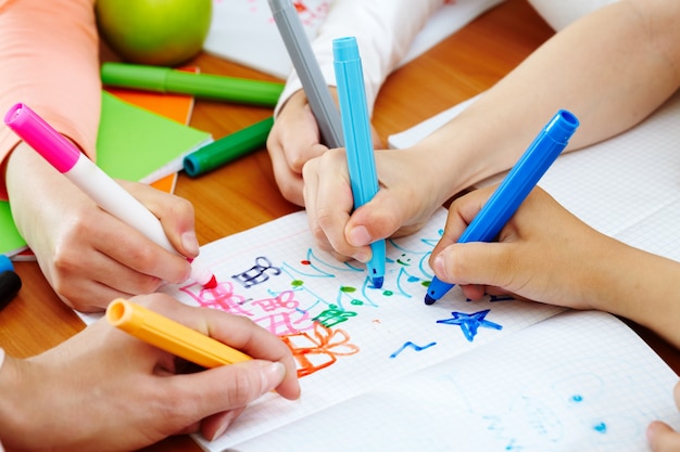 Primer plano de manos pintando un cuaderno