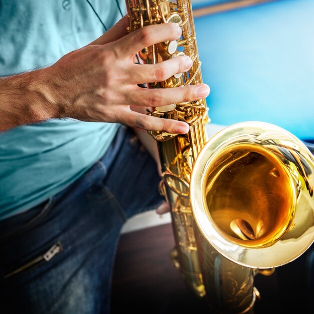 Primer plano de manos tocando el saxofón