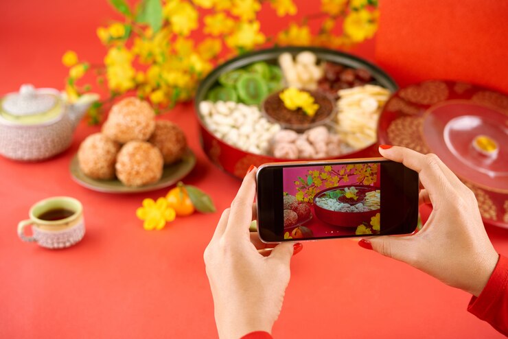 Foto gratuito primer plano de las manos tomando fotos de comida de vacaciones tet en la cámara del teléfono inteligente