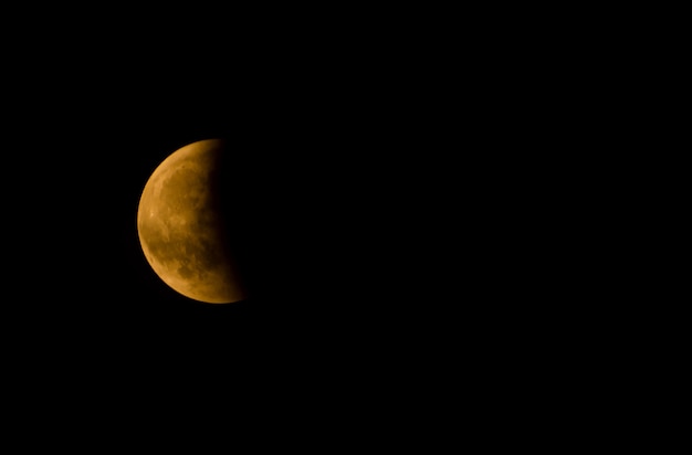 Primer plano de una media luna contra un cielo oscuro