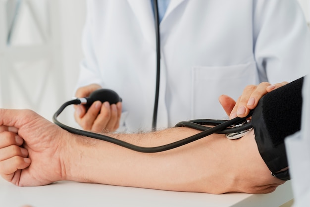 Primer plano médico inflando el manguito de presión arterial
