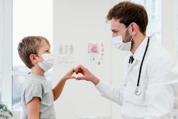 Primer plano médico y niño con máscaras