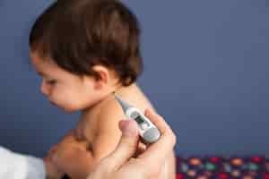 Foto gratuita primer plano médico revisando la temperatura del bebé