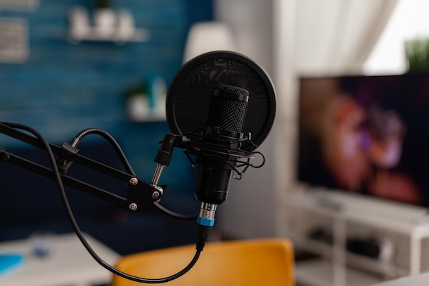 Primer plano del micrófono de grabación en el estudio casero. Equipo profesional de transmisión en vivo para grabar contenido en redes sociales. Tecnología de transmisión en vivo de audio electrónico en el escritorio. Instrumento de podcast.