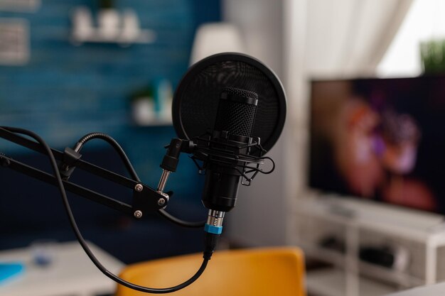 Primer plano del micrófono de grabación en el estudio casero. Equipo profesional de transmisión en vivo para grabar contenido en redes sociales. Tecnología de transmisión en vivo de audio electrónico en el escritorio. Instrumento de podcast.