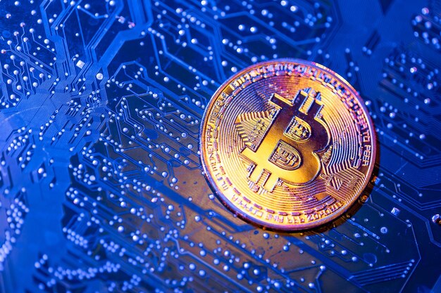 Primer plano de la moneda Bitcoin en la placa de circuitos Concepto financiero