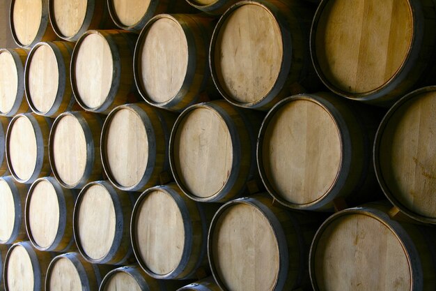 Primer plano de un montón de barriles de vino de madera