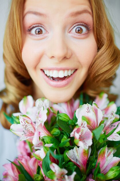 Primer plano de mujer alegre con ramo de flores