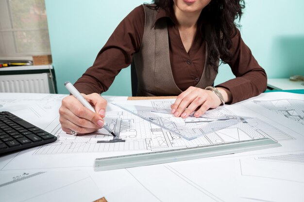 Primer plano de mujer arquitecta en su escritorio de trabajo. Trabajando en nuevos proyectos. Arquitectura y Diseño