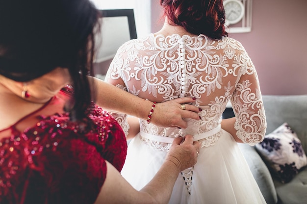 Primer plano de una mujer arreglando el vestido de novia