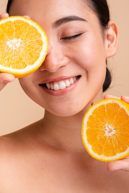 Primer plano mujer asiática feliz con naranja