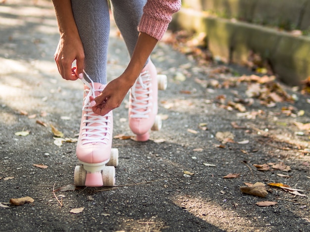 Foto gratuita primer plano de mujer atar cordones de los zapatos en patines con espacio de copia