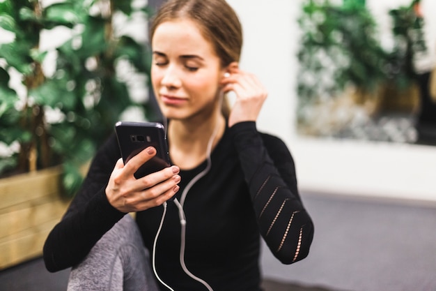 Primer plano de una mujer atlética escuchando música