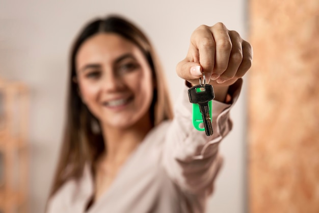 Primer plano mujer borrosa sosteniendo llaves