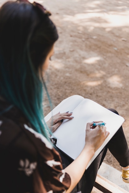 Primer plano, de, un, mujer, bosquejar, en, cuaderno, con, pluma